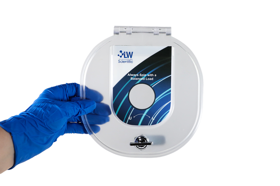 Blue-gloved hand holding a clear protective lid for the LW Scientific E8 centrifuge.